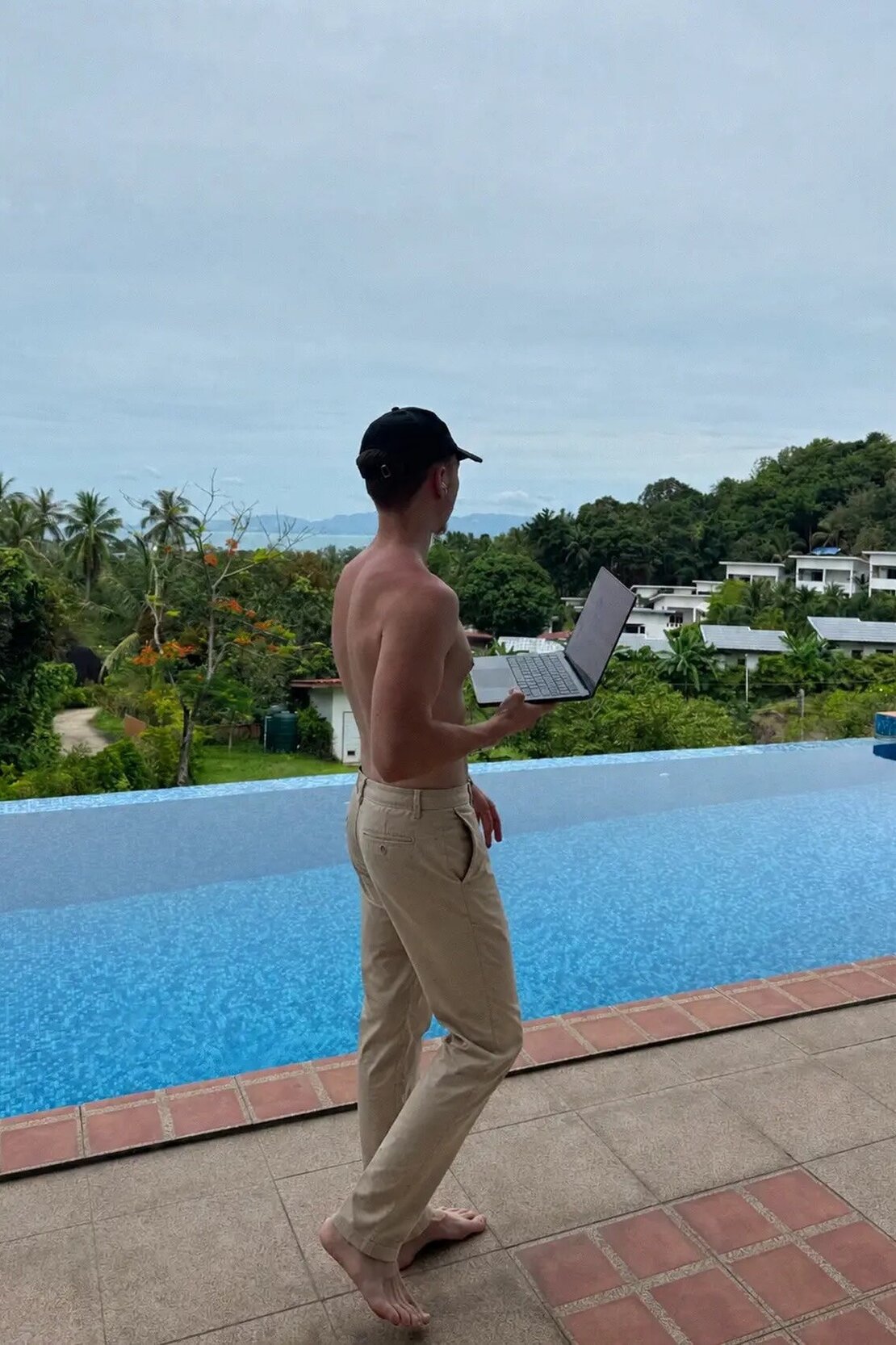 Eric Otten working on his laptop by a pool